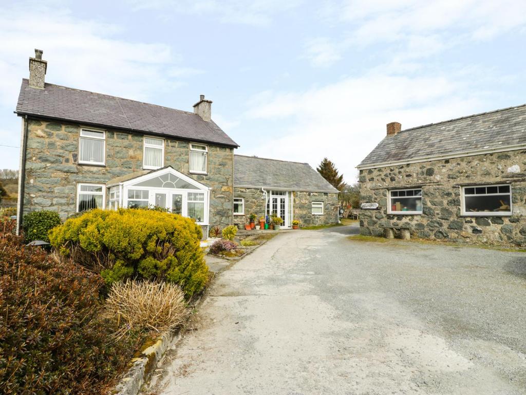 a stone house with a driveway in front of it at Bwthyn Ael Y Bryn in Dolbenmaen