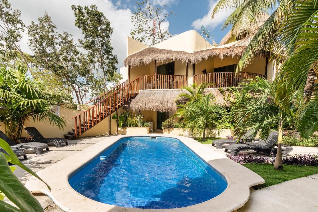 uma villa com piscina em frente a uma casa em Villas Akalan em Tulum