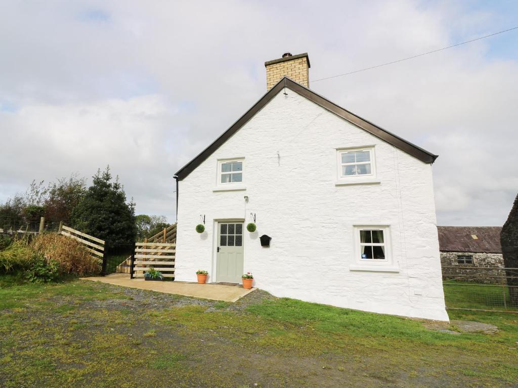 a white house with a black roof at Penglanowen Fawr in Rhostie