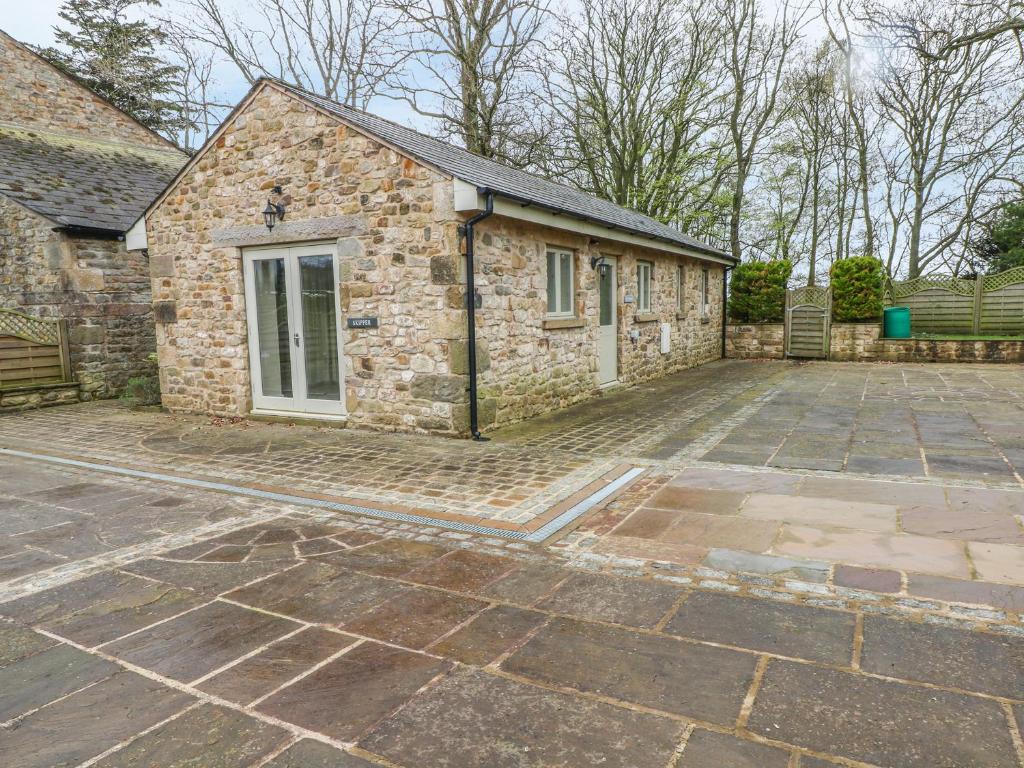 a stone house with a large driveway in front of it at Skipper in Lancaster