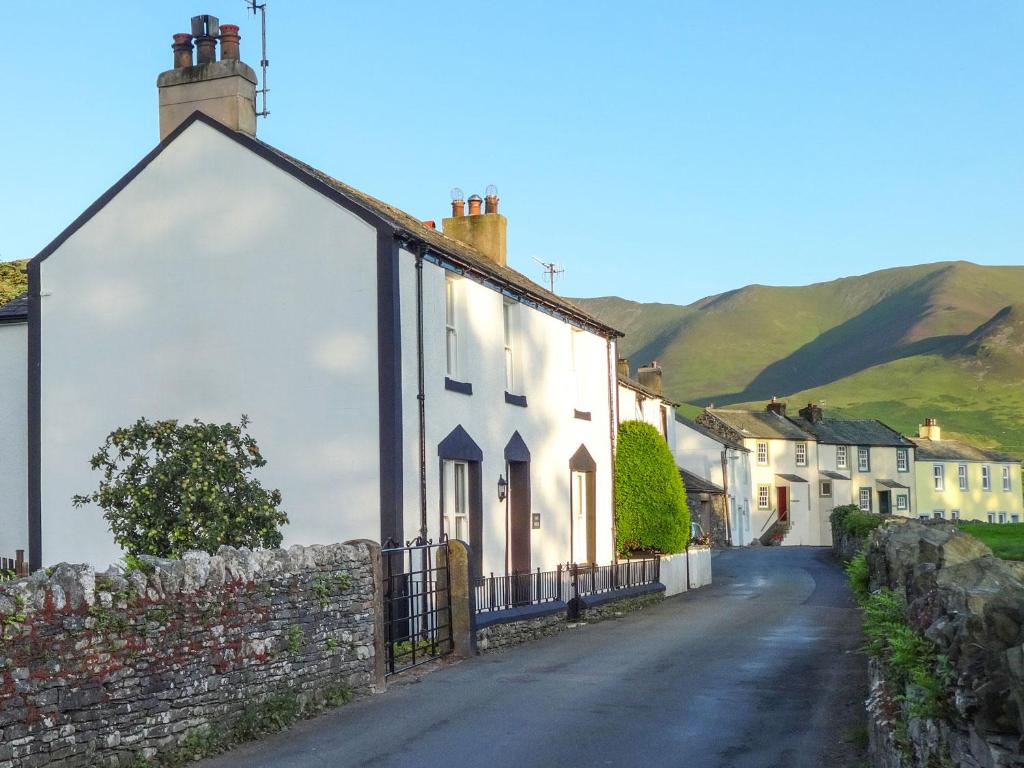 a white house on a street with mountains in the background at Dale House in Cockermouth