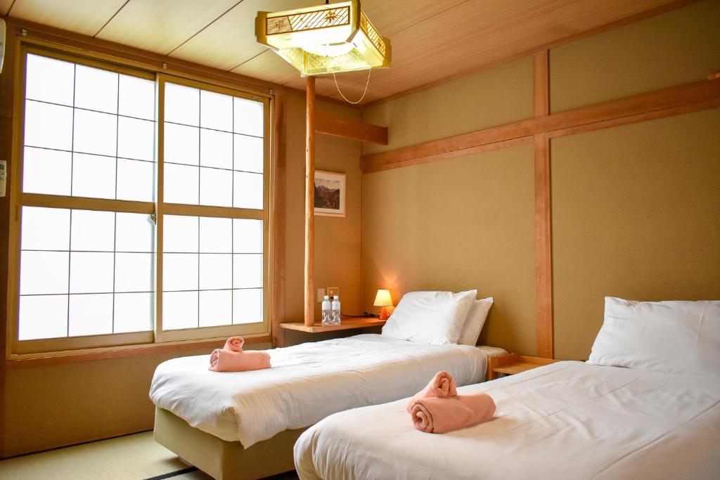 Postel nebo postele na pokoji v ubytování Asuka Lodge
