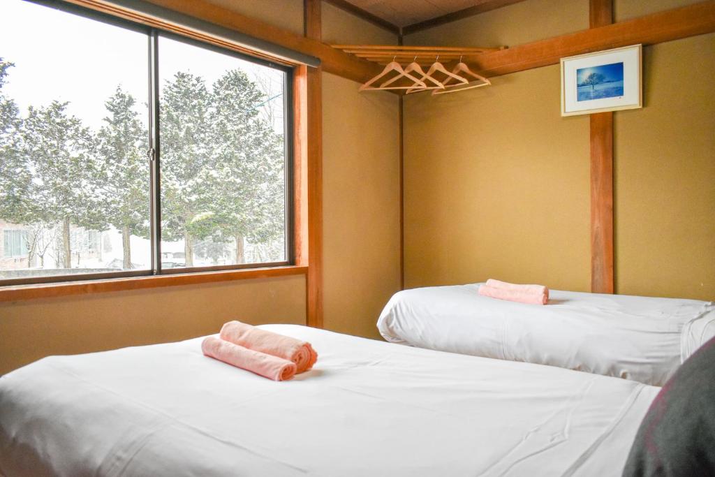 Postel nebo postele na pokoji v ubytování Asuka Lodge