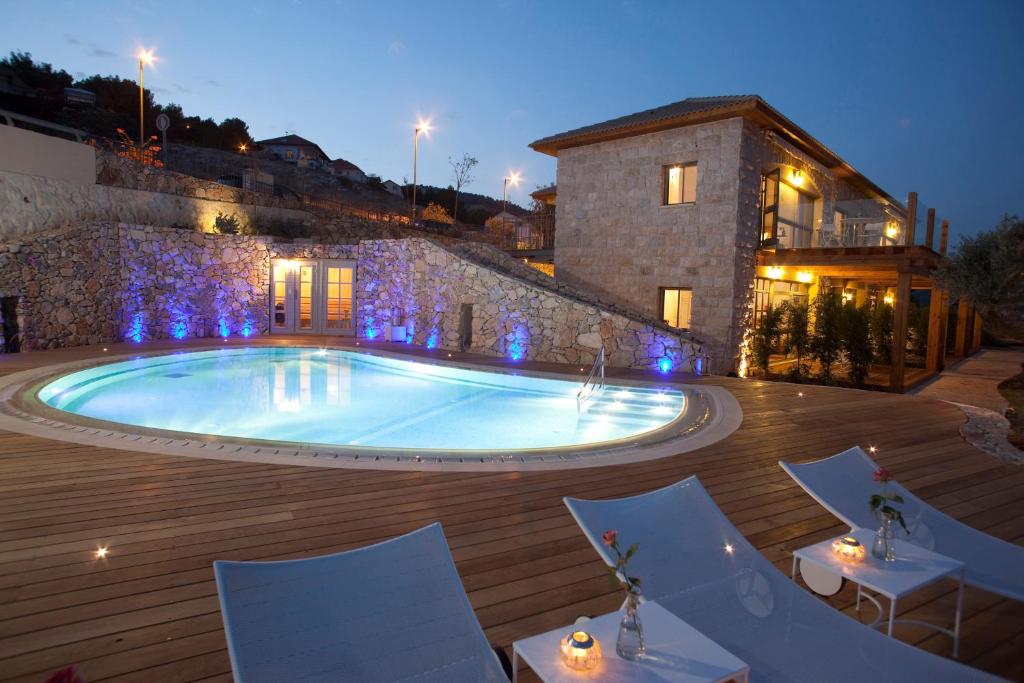 a large swimming pool with chairs and a building at Boutique Hotel Tamarin in Rosh Pinna