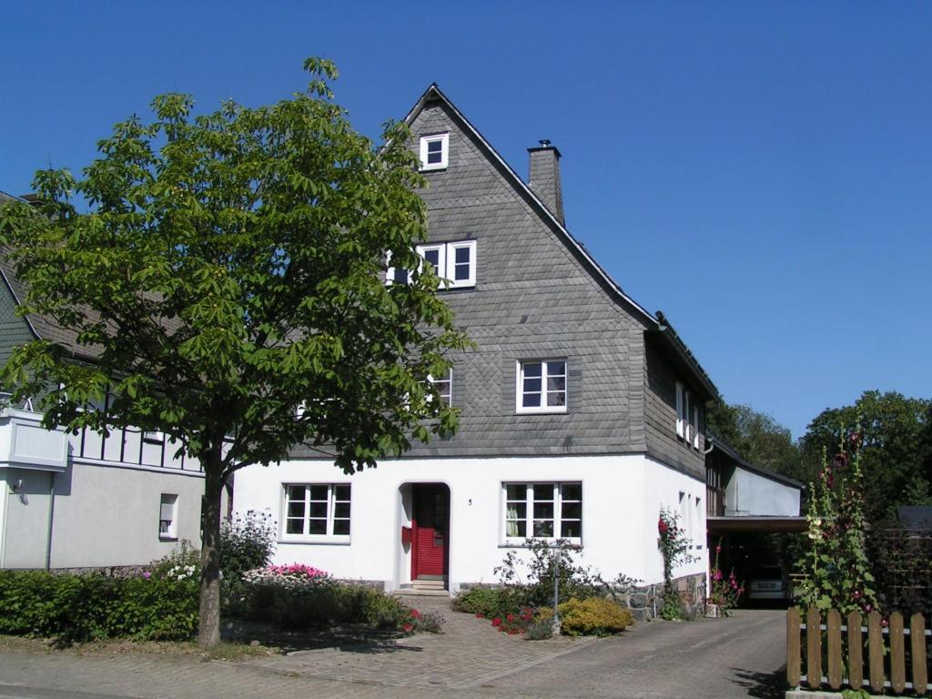 a white house with a red door at Bed And Breakfast Isidorus in Winterberg