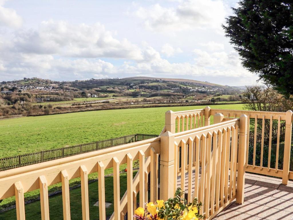 a white fence with a view of a green field at Little Acorn in Barnstaple