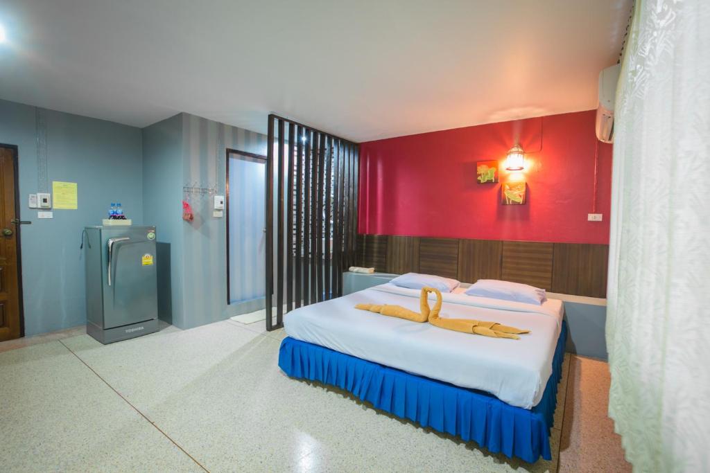 1 dormitorio con 1 cama grande y pared roja en Phang Nga Guesthouse en Phangnga