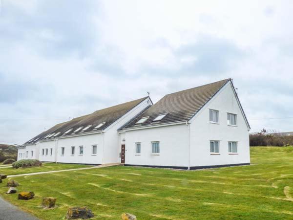 a large white building with a grass yard at Isallt Lodge in Holyhead