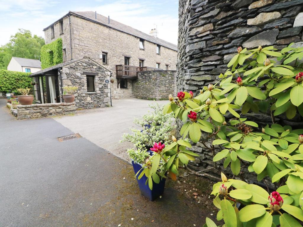 a stone building with flowers on the side of it at The Hayloft in Grange Over Sands