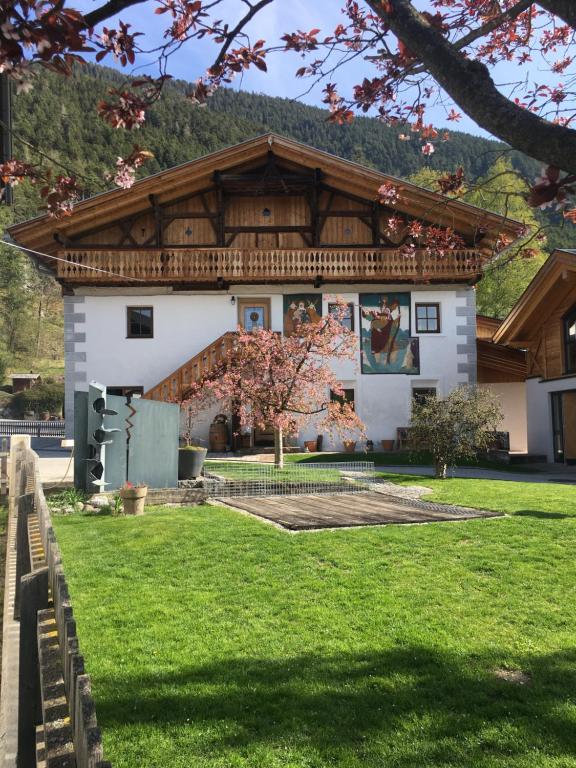 a white building with a wooden roof at Apartment Der Riese in Reith bei Seefeld