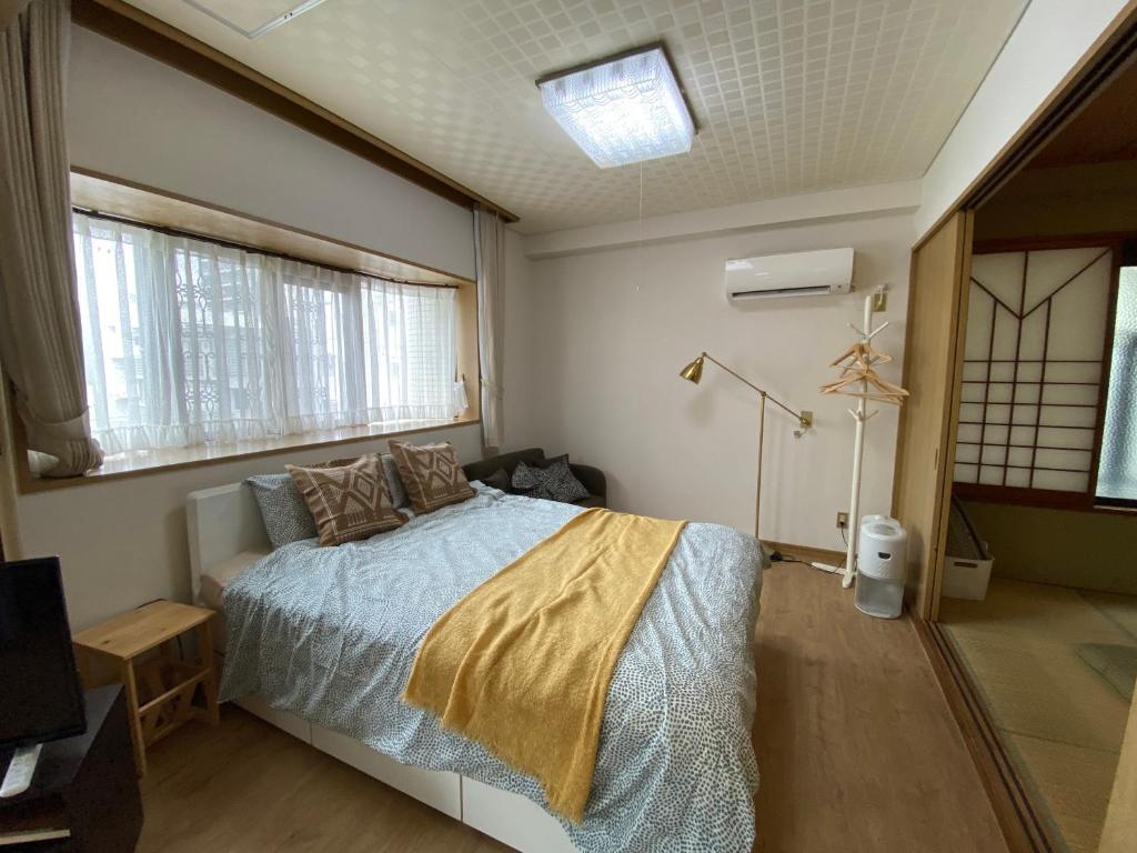 um quarto com uma cama num quarto com janelas em Second Habor Beach House em Naha