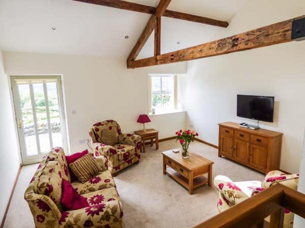 a living room with two couches and a tv at Ghyll Bank Barn in Staveley
