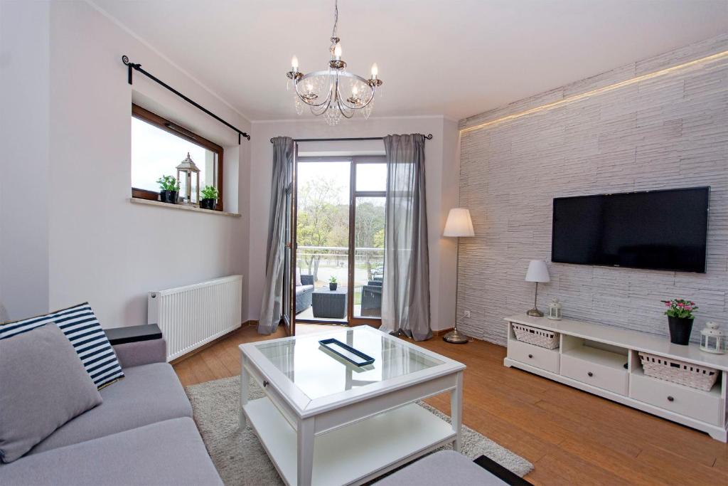 a living room with a couch and a tv at Perła Rentyear Apartments in Gdańsk