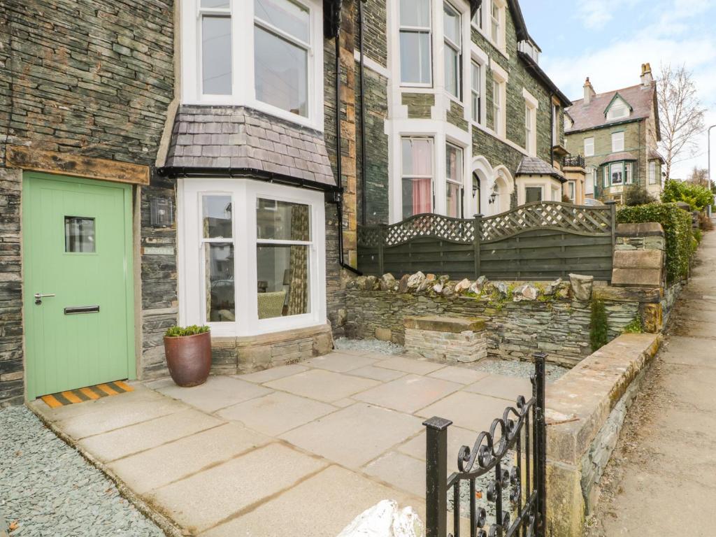 a house with a green door on a street at Roselea in Keswick