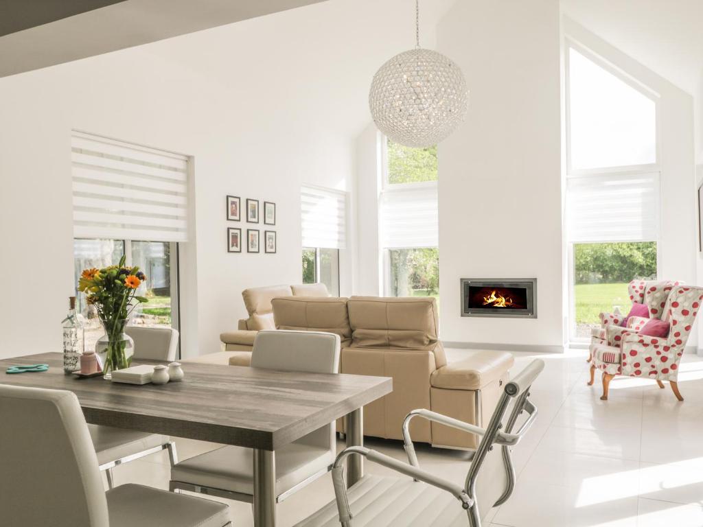 a white living room with a table and chairs at P'lace of Glassaugh in Banff