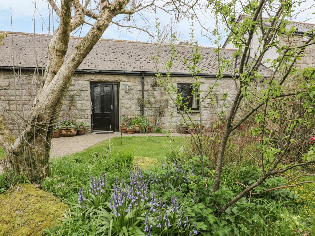 a stone house with a garden in front of it at Brunnion Cottage in Hayle