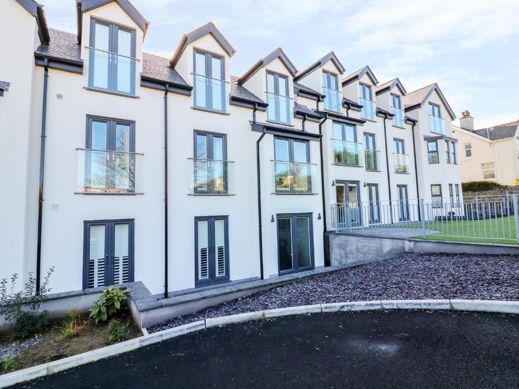 a row of white houses with a driveway at 6 Bay View in Benllech