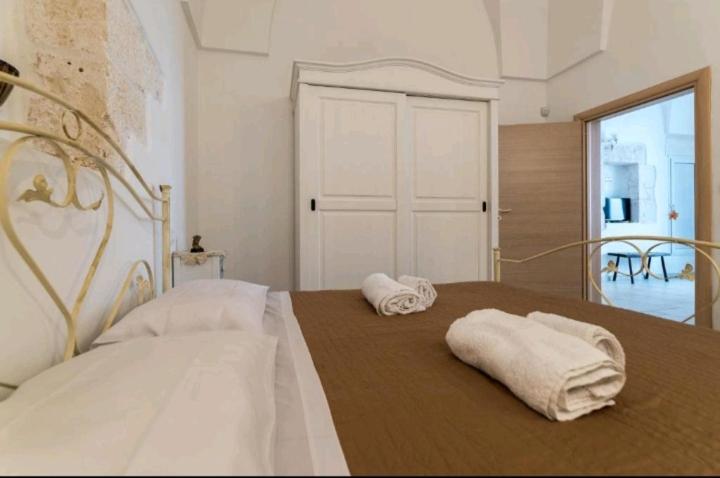 um quarto com duas camas com toalhas em La perla bianca em Ostuni