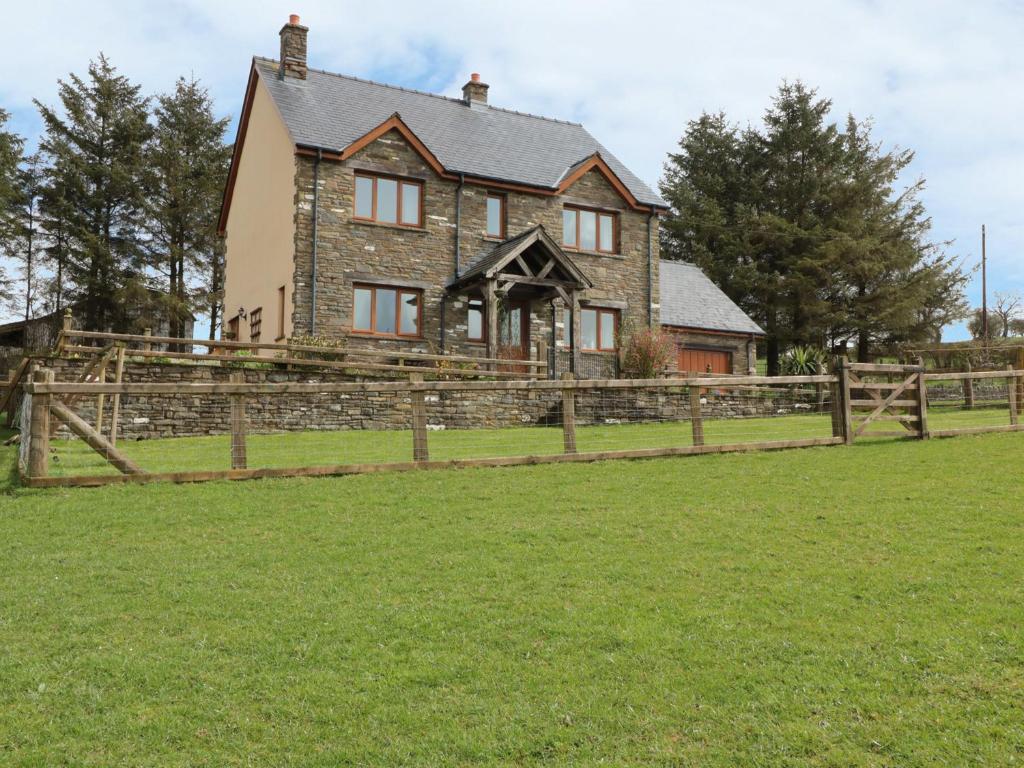 una casa con una valla delante de un campo en Blaen Henllan en Aberedw