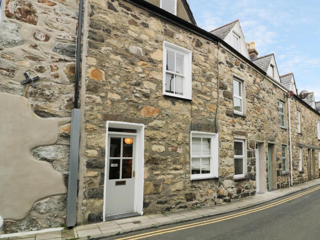 an old stone building on the side of a street at 19A Kingshead Street in Pwllheli