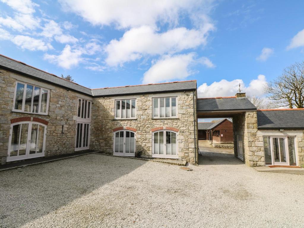 an old stone house with a large driveway at Argal in Penryn