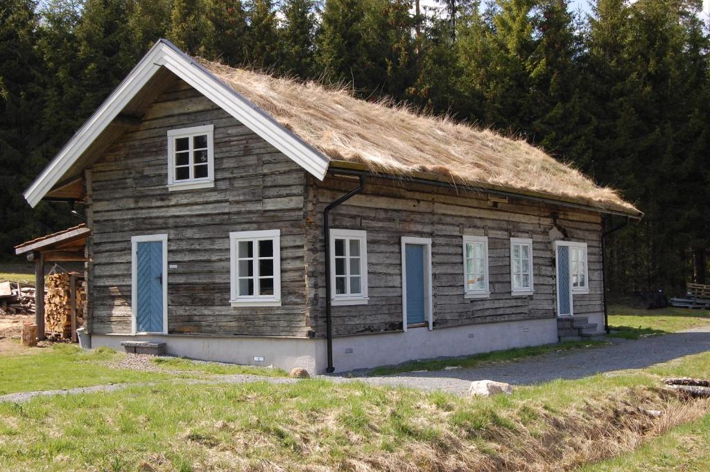 una antigua casa de madera con techo de hierba en Eskebo, en Torestorp