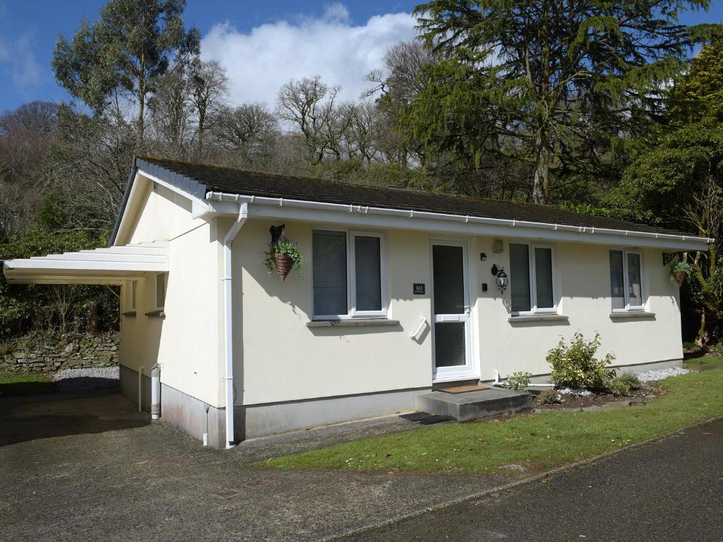 a small white house with a garage at Little Retreat in Liskeard