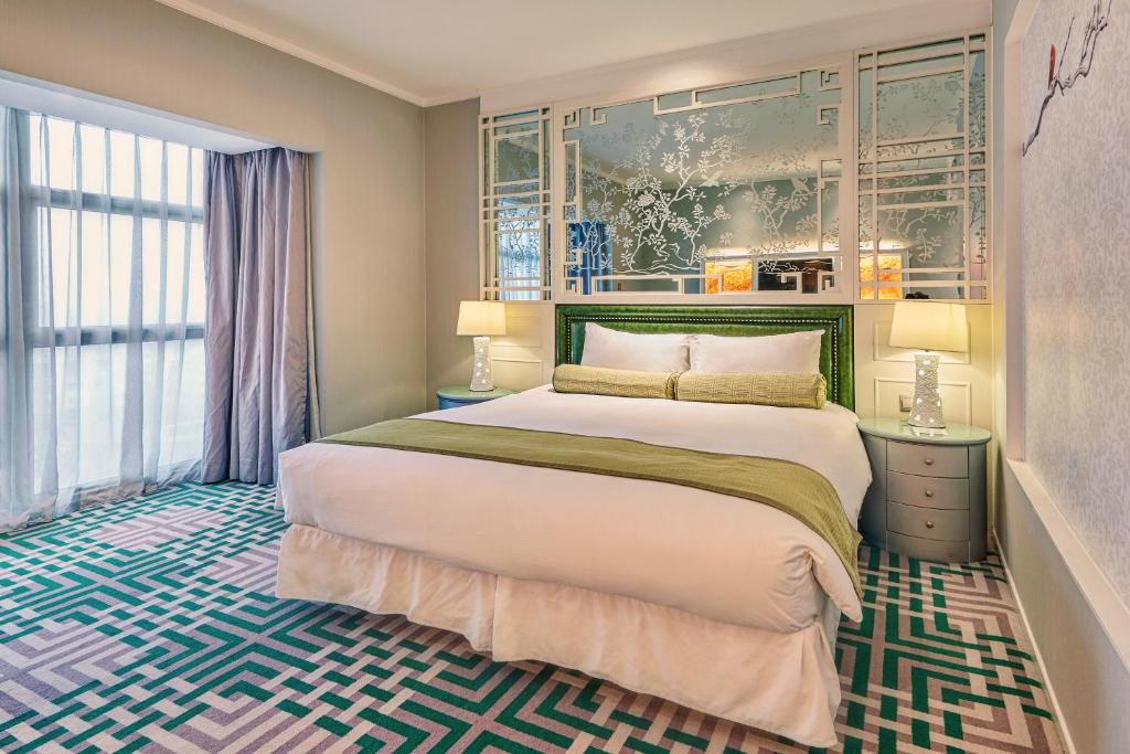 a bedroom with a large bed and a large window at Dorsett Shanghai in Shanghai