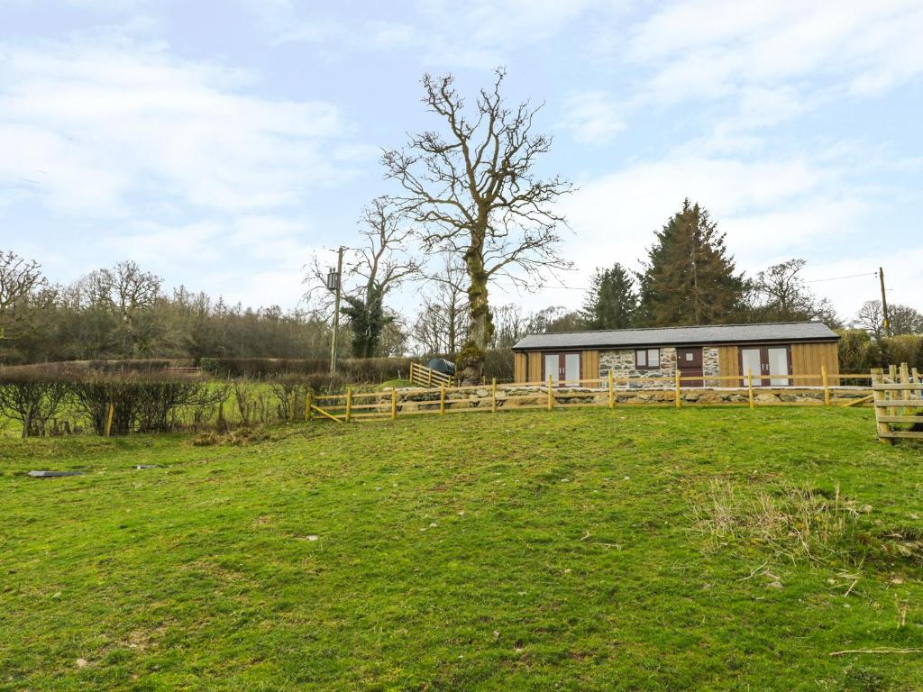 a house in a field with a fence at Bothi in Bala