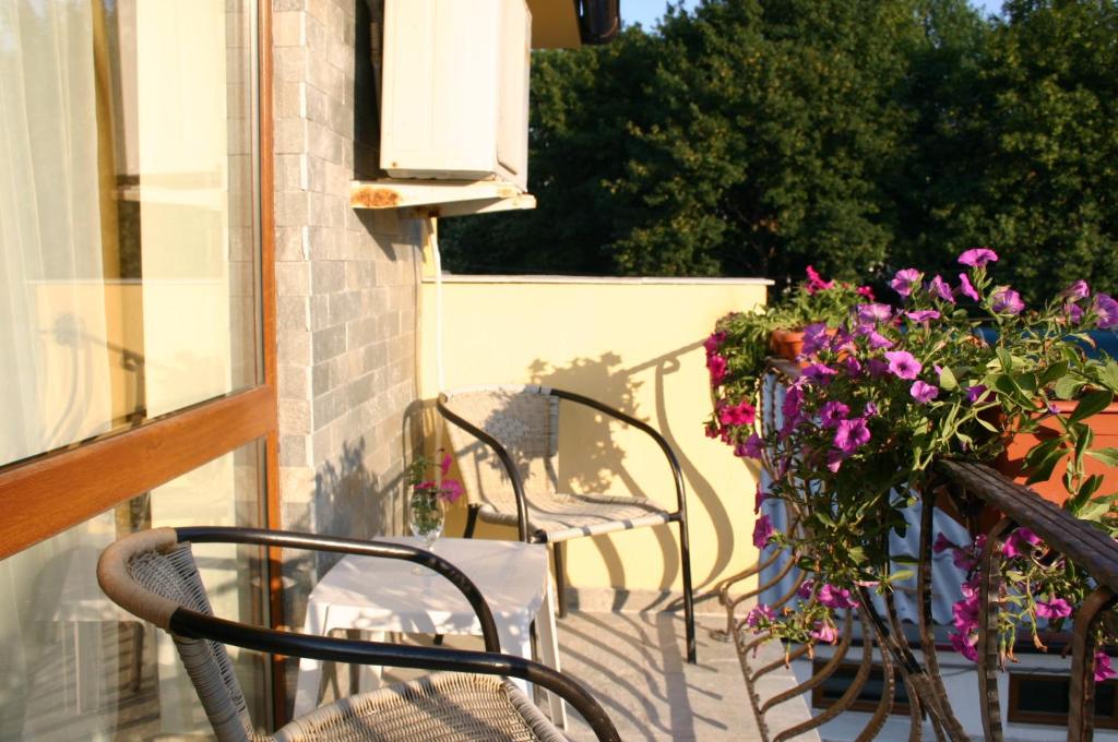 a group of chairs sitting on a balcony with flowers at Hotel Grand in Eforie Nord