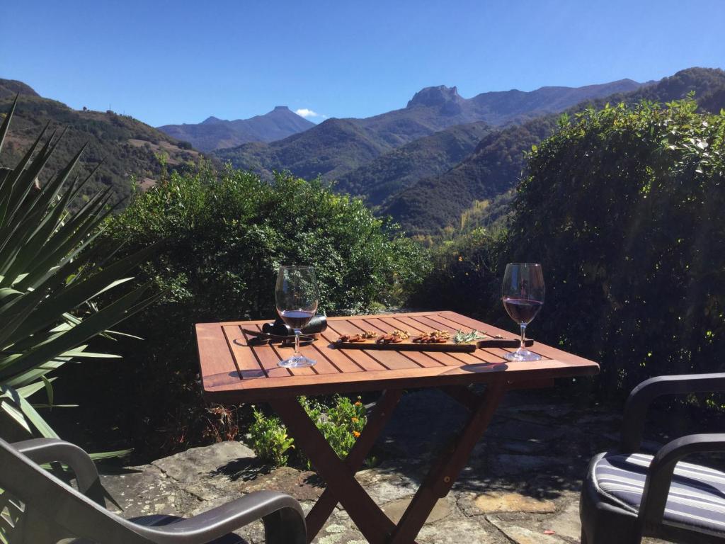 a wooden table with two glasses of wine on it at Olmares Terrace Apartment - Picos de Europa in Lomeña