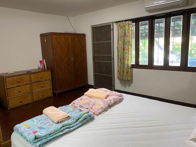 a bedroom with a bed with two towels on it at Dikachaya Hostel in Chaweng