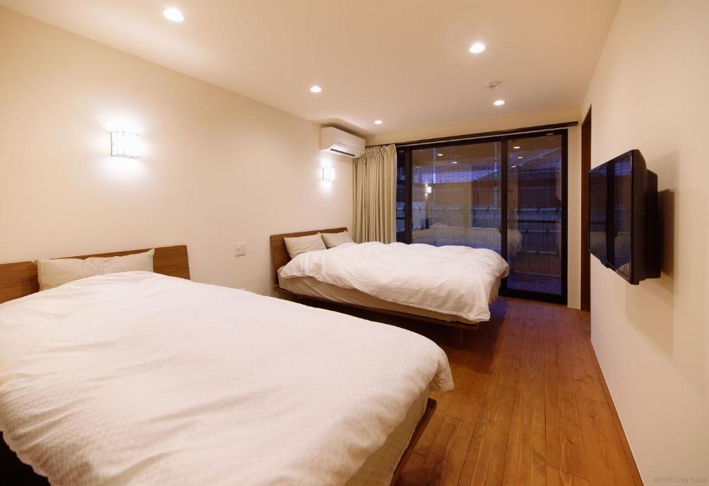 Duas camas num quarto com uma janela em Miyabi Cosy House em Quioto