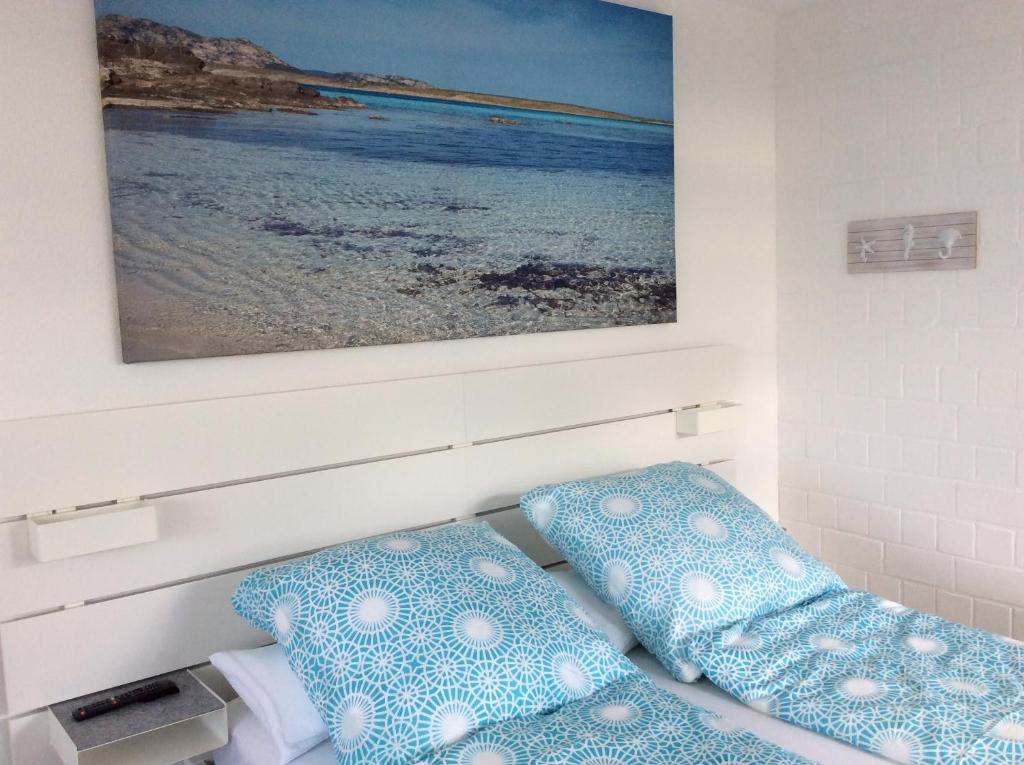 una camera da letto con cuscini blu e bianchi e un dipinto di Wellness Apartment Sankt Englmar a Sankt Englmar