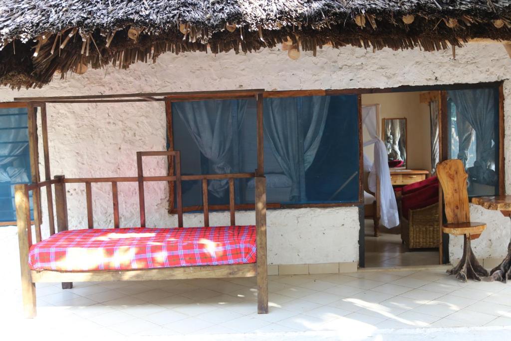 Bett vor einem Haus mit Fenster in der Unterkunft A wonderful Beach property in Diani Beach Kenyaa dream holiday place in Mombasa