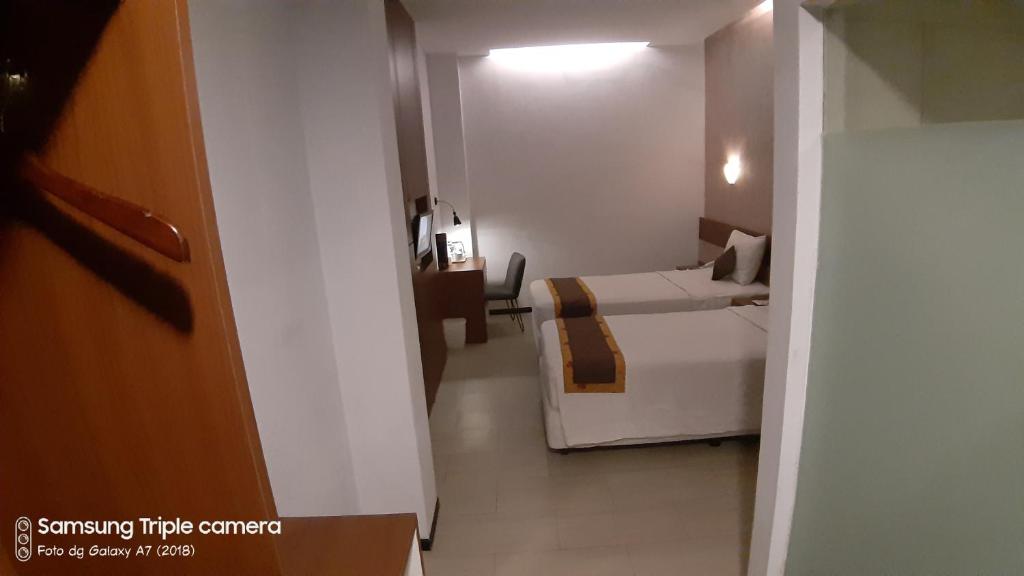 a small room with a bedroom with a bed in it at Xtra Hotel Bengkulu in Bengkulu