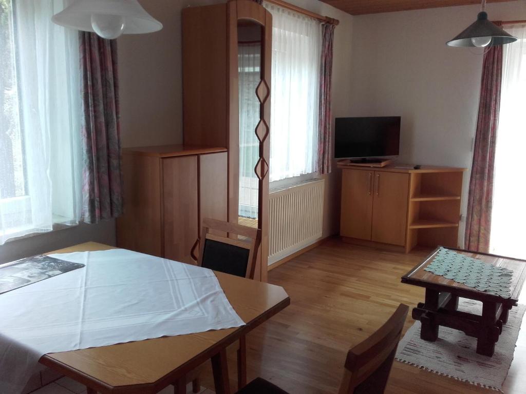 een woonkamer met een tafel en een televisie bij Apartment Marianne in Bad Gastein