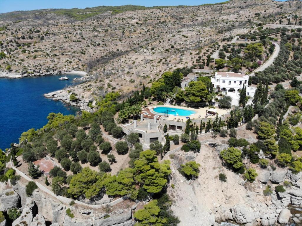 an aerial view of a house on a cliff next to the water at Pyrgi Spetses in Spetses