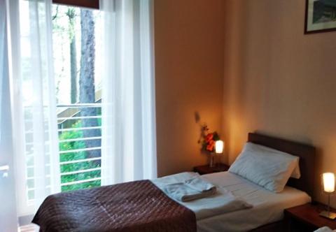 a bedroom with a bed and a large window at Hotel Arena in Rybnik