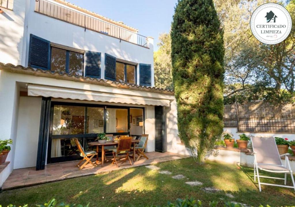 a house with a yard with a table and chairs at Sa Graonada in Calella de Palafrugell