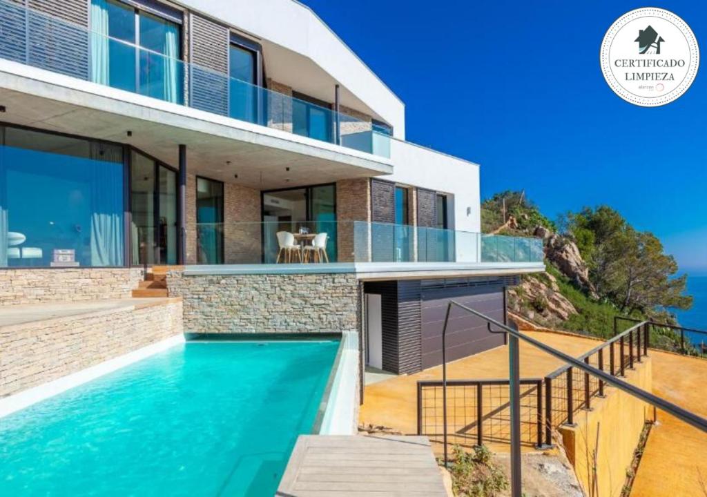 een huis met een zwembad ervoor bij Villa El Mirador in Begur