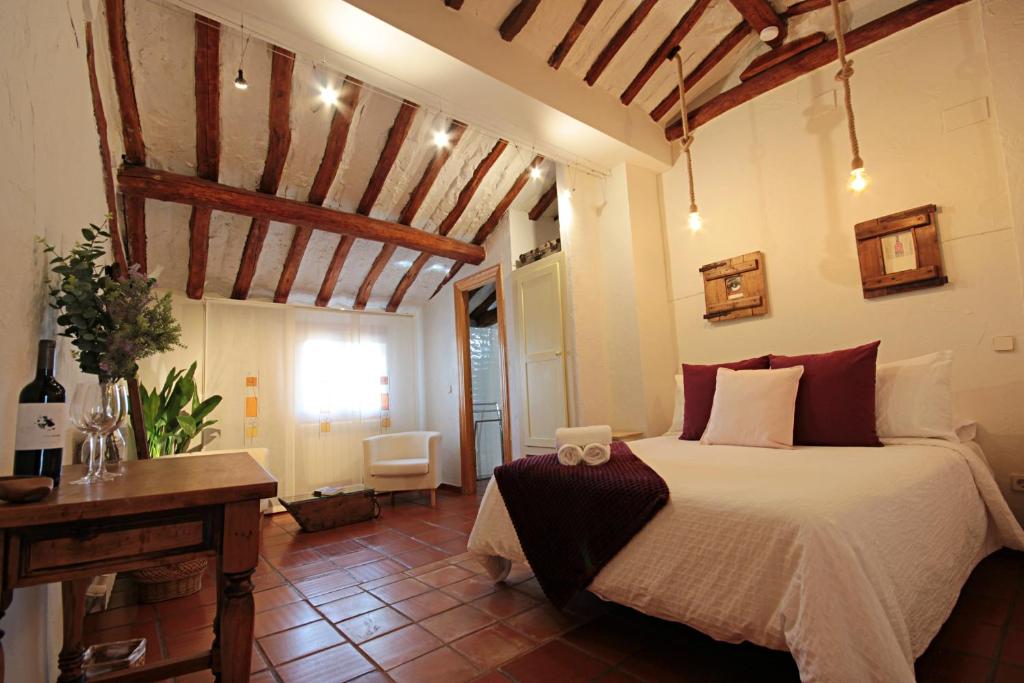 a bedroom with a bed in a room with wooden ceilings at Domitila Rooms in Clavijo