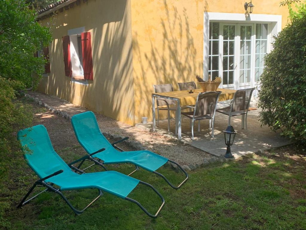 um grupo de cadeiras e uma mesa num quintal em Gîte les Cyprès (Bastide Sainte Agnès) em Carpentras