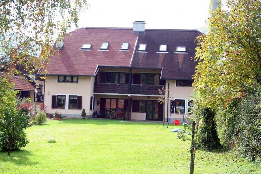 a large house with a large yard in front of it at Apartments Lovšin in Mozirje