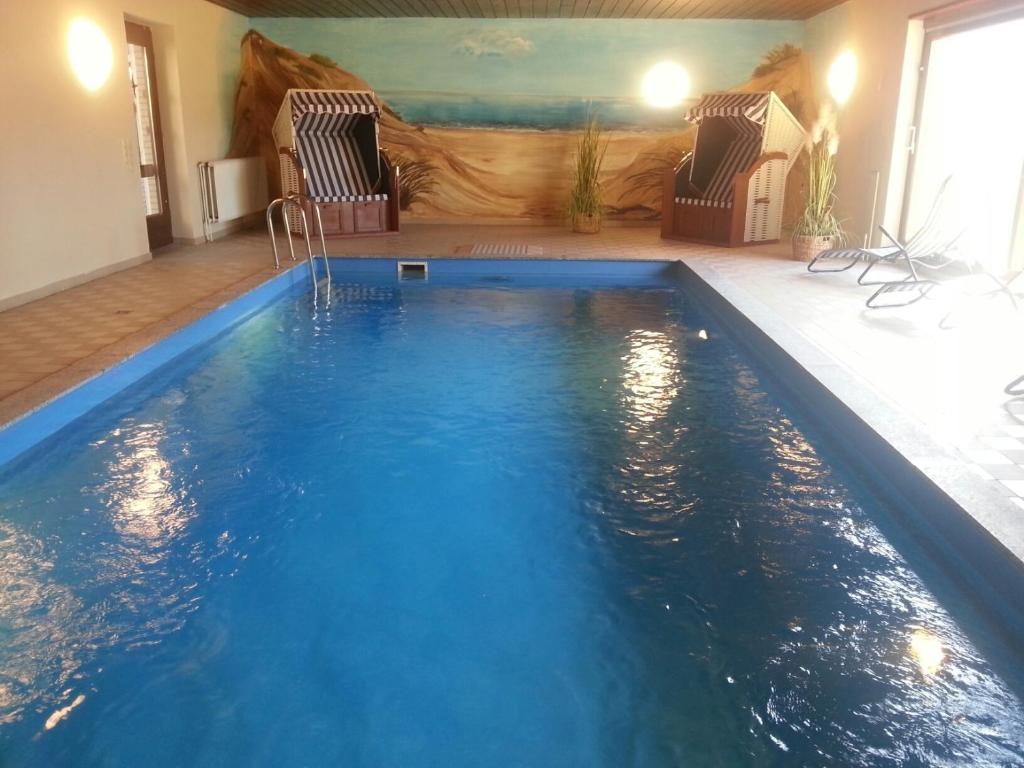 einen Pool in einem Zimmer mit 2 Stühlen in der Unterkunft Landhaus Vollmer in Büsum