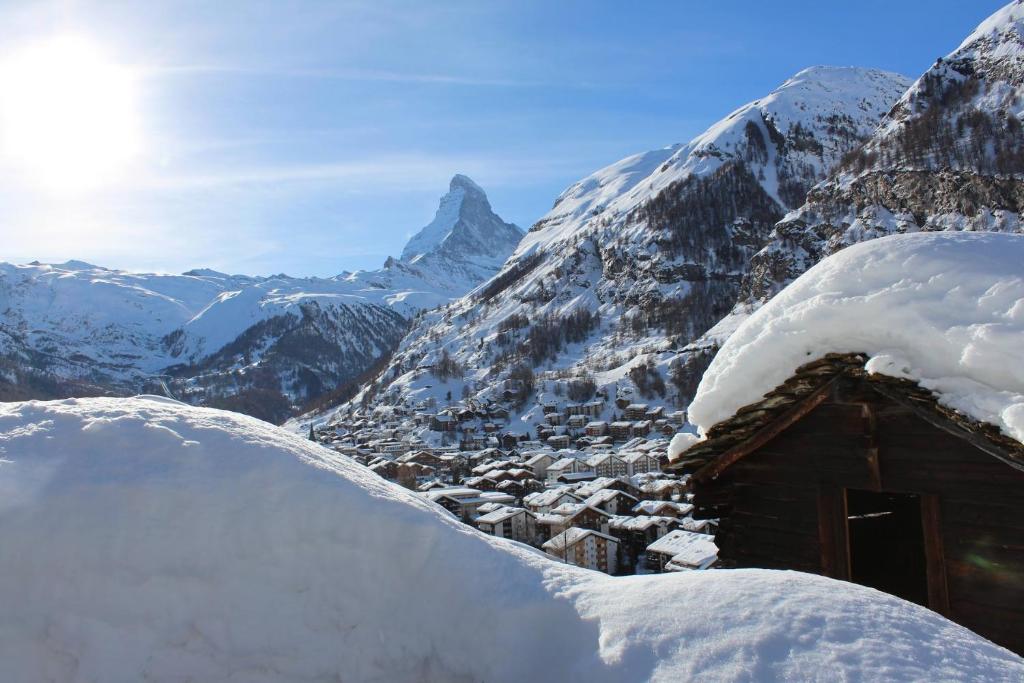 a snow covered mountain with a cabin in the foreground at Chalet Gädi in Zermatt