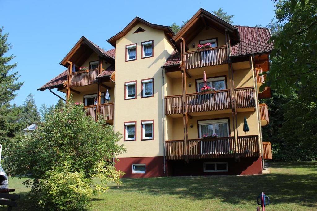 ein großes Apartmenthaus mit Balkonen und Bäumen in der Unterkunft Ferienhaus Drobesch in Sankt Kanzian am Klopeiner See