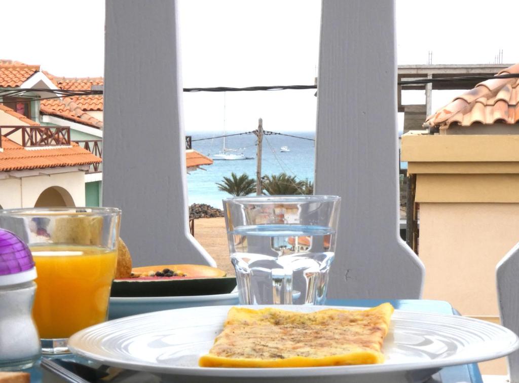 un piatto con un pezzo di pane tostato e un bicchiere di succo d'arancia di Hotel MiraBela a Santa Maria