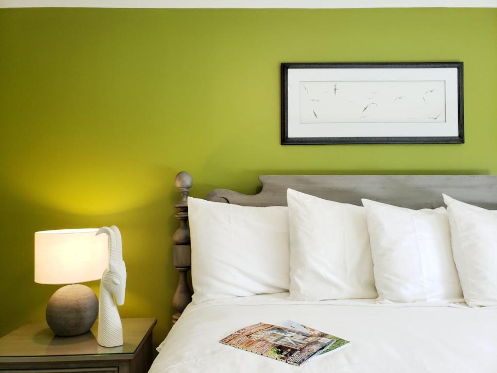 sypialnia z zielonymi ścianami i łóżkiem z białymi poduszkami w obiekcie The Primrose w mieście Bar Harbor