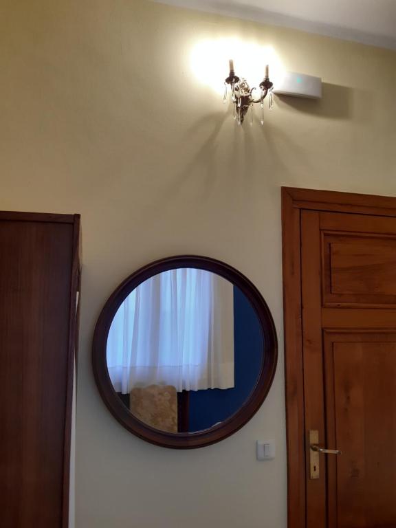 a mirror on a wall with a light and a door at Hotel Hontoria in Hontoria